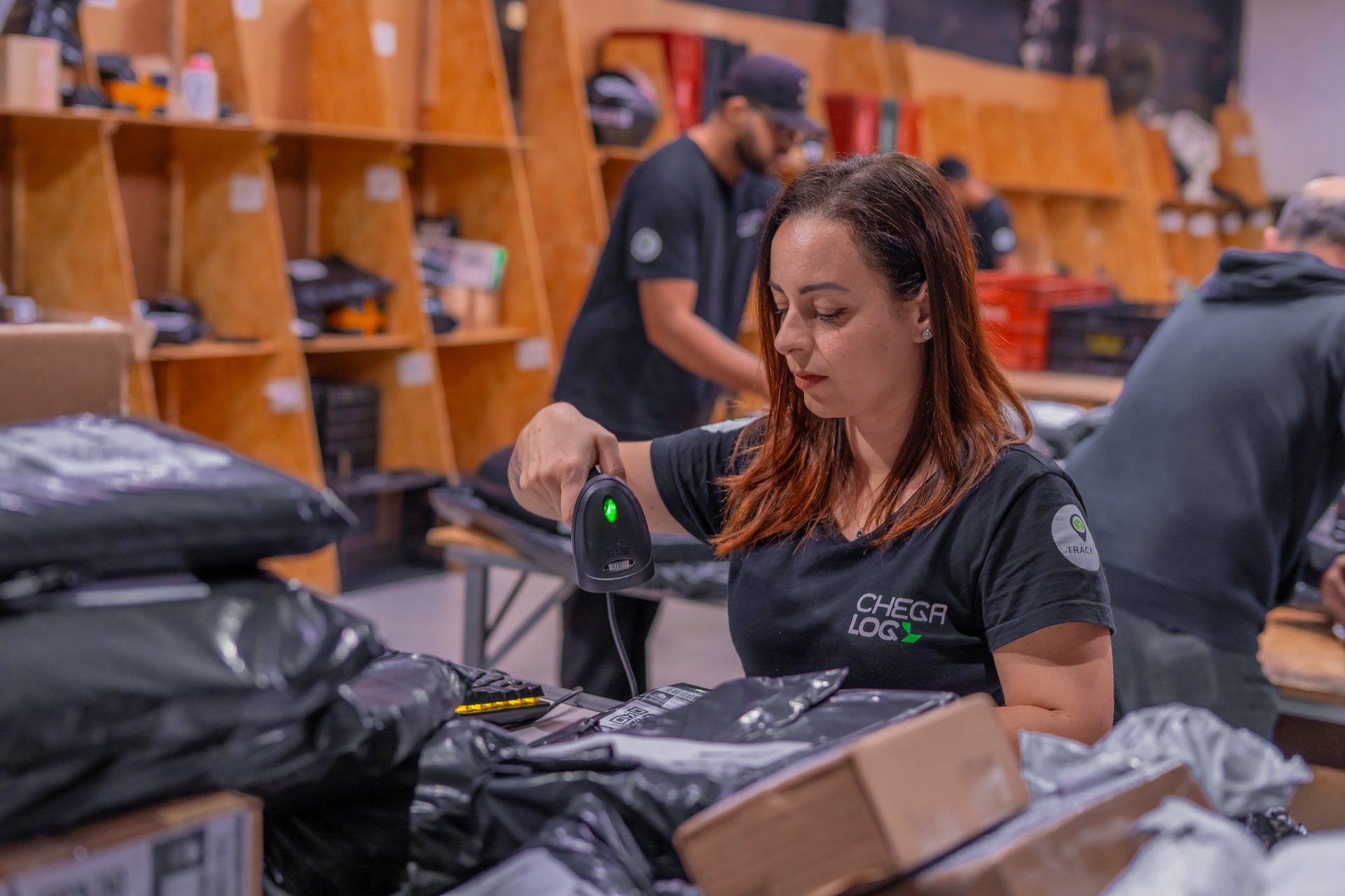 Colaborador da ChegaLog embalando um pedido na bancada de expedição